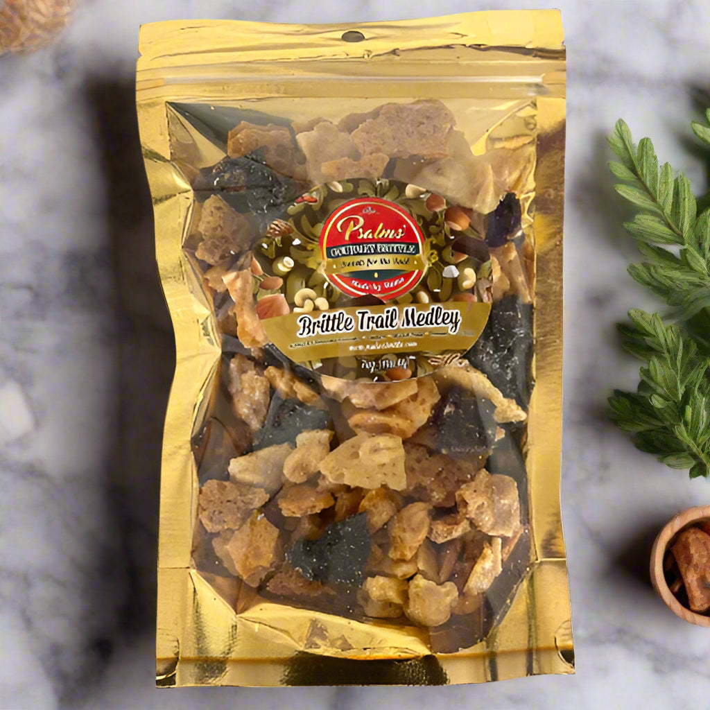 A clear, resealable pouch labeled ‘Brittle Trail Medley by Psalms Gourmet Brittle,’ filled with crunchy brittle pieces, roasted nuts, seeds, and dried fruit.